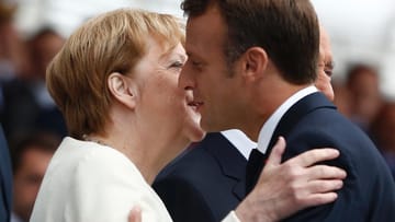 Begrüßung mit Küsschen: Bundeskanzlerin Merkel und Frankreichs Präsident Macron am Sonntag in Paris.