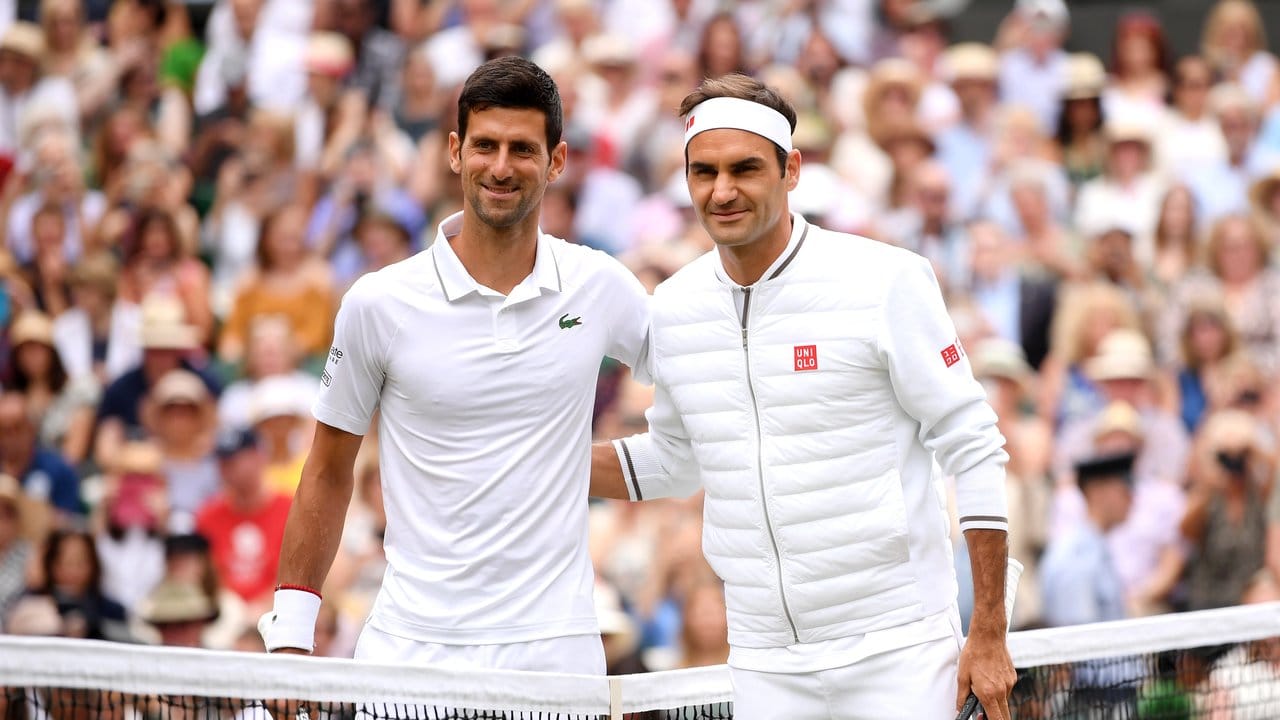Novak Djokovic (l) und Roger Federer lächeln vor dem Spiel in die Kamera.