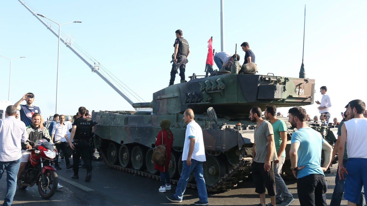 Türkische Polizisten und Anhänger von Präsident Erdogan stehen nach dem gescheiterten Putsch in der Nähe von Panzern auf der Bosporusbrücke in Istanbul.