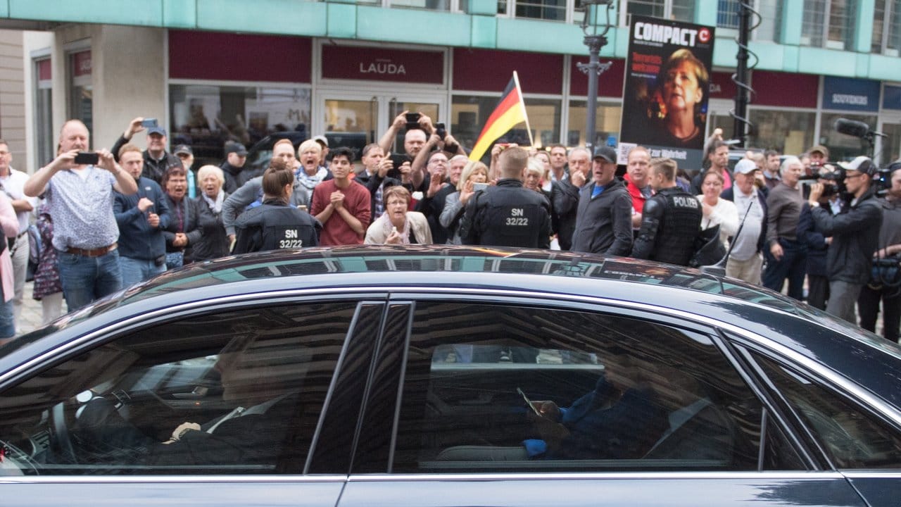 Der Dienstwagen der Bundeskanzlerin fährt an Demonstranten vor dem Albertinum vorbei. Der Dienstwagen der Bundeskanzlerin fährt an Demonstranten vor dem Albertinum vorbei.