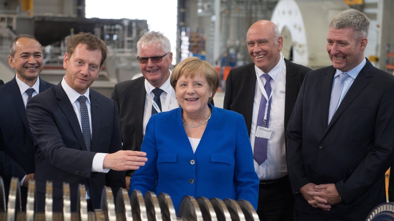 Bundeskanzlerin Angela Merkel steht zusammen mit Sachsens Ministerpräsident Michael Kretschmer (l) im Siemens-Werk in Görlitz.
