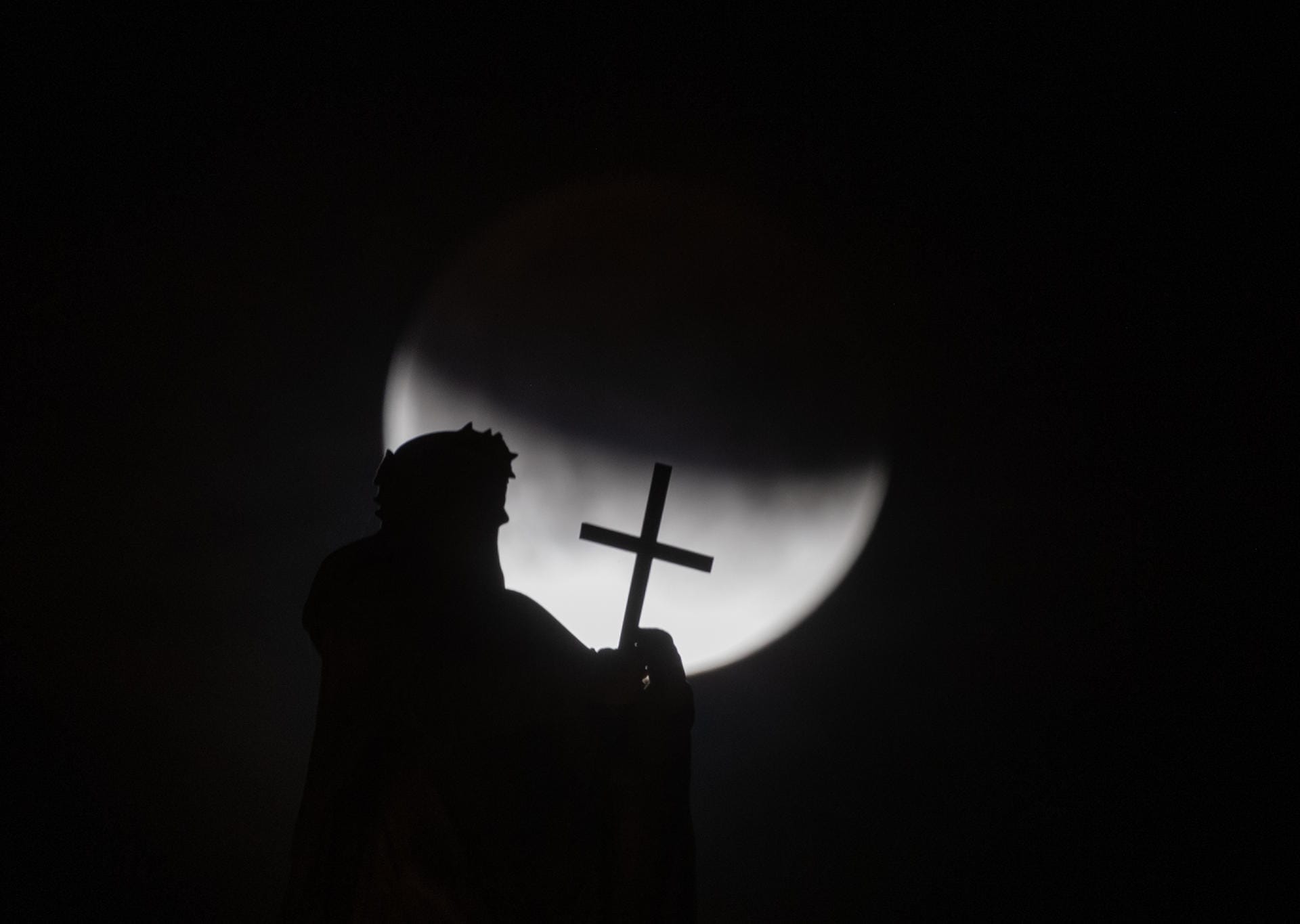 Der Mond ist hinter einer der Mattielli-Statuen auf der Katholischen Hofkirche in Dresden zu sehen: Fast zwei Drittel des Mondes lagen in der Nacht im Schatten.