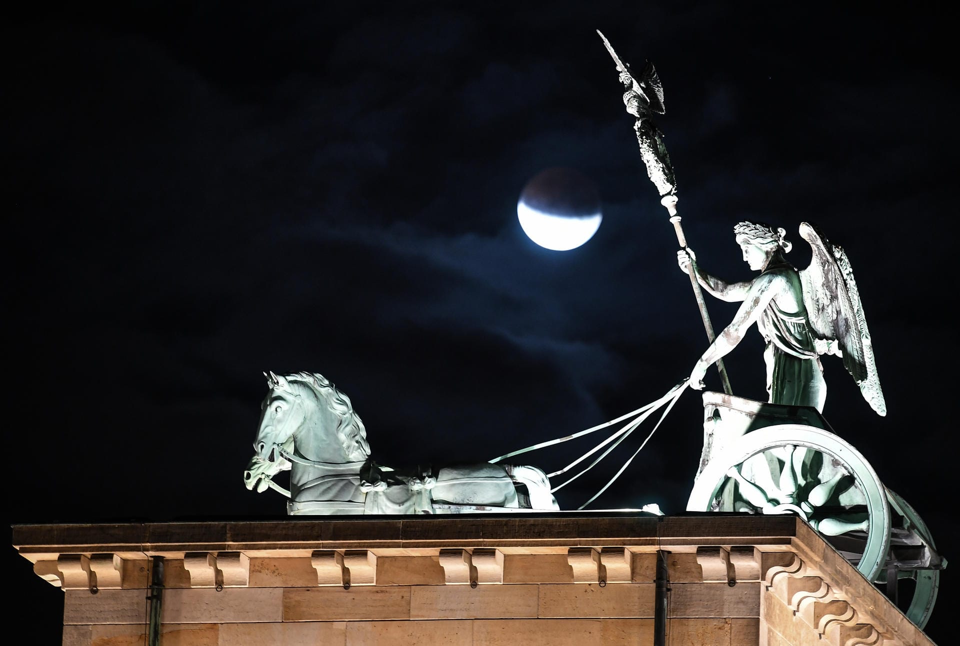 Berlin: Der Mond ist während einer partiellen Mondfinsternis hinter der Quadriga des Brandenburger Tors zu sehen.