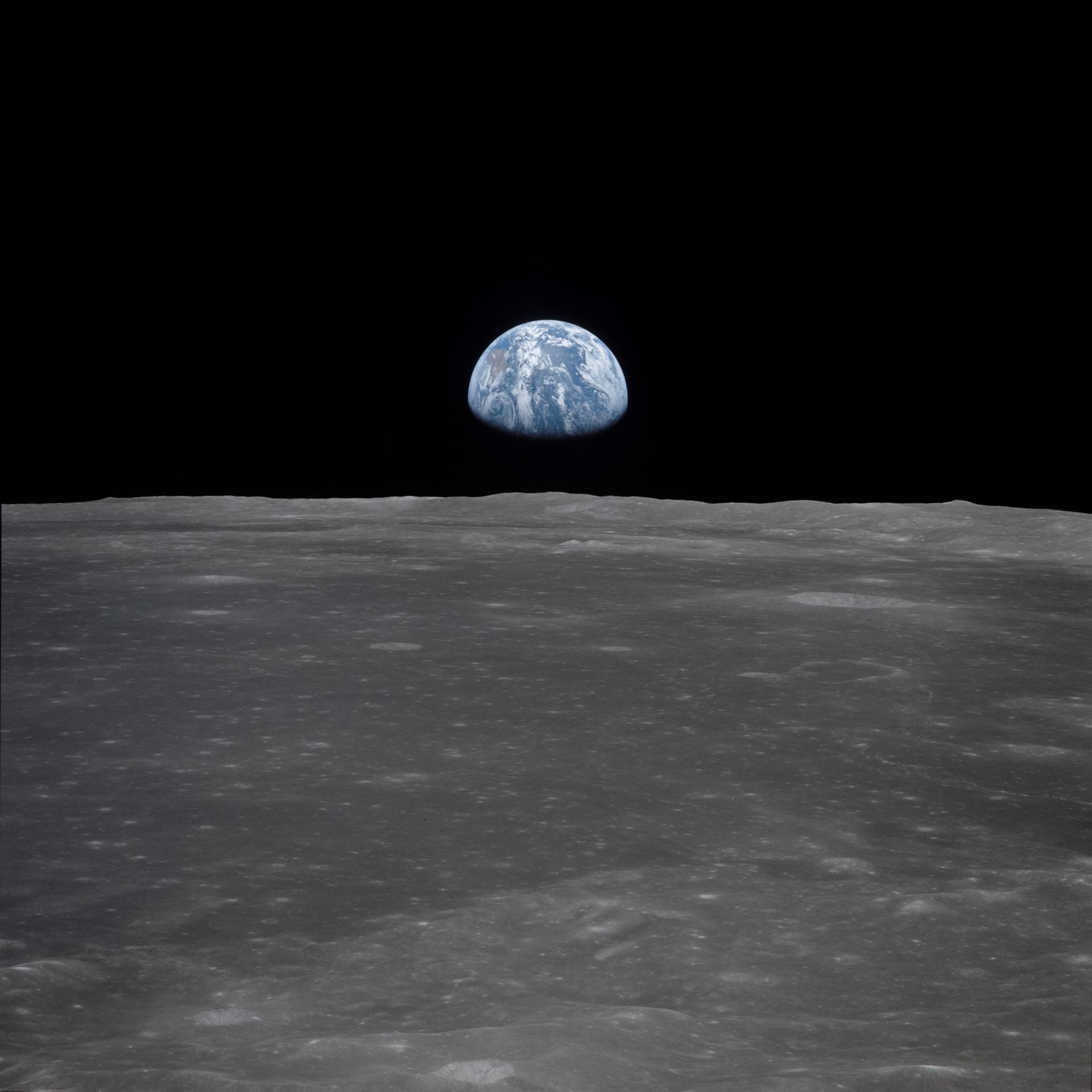Während Armstrong und Aldrin den Mond zu Fuß erkundeten, blieb Michael Collins in der Mondfähre zurück. Von dort nahm er dieses Bild auf, das zeigt, wie die Erde über dem Horizont des Mondes aufsteigt.