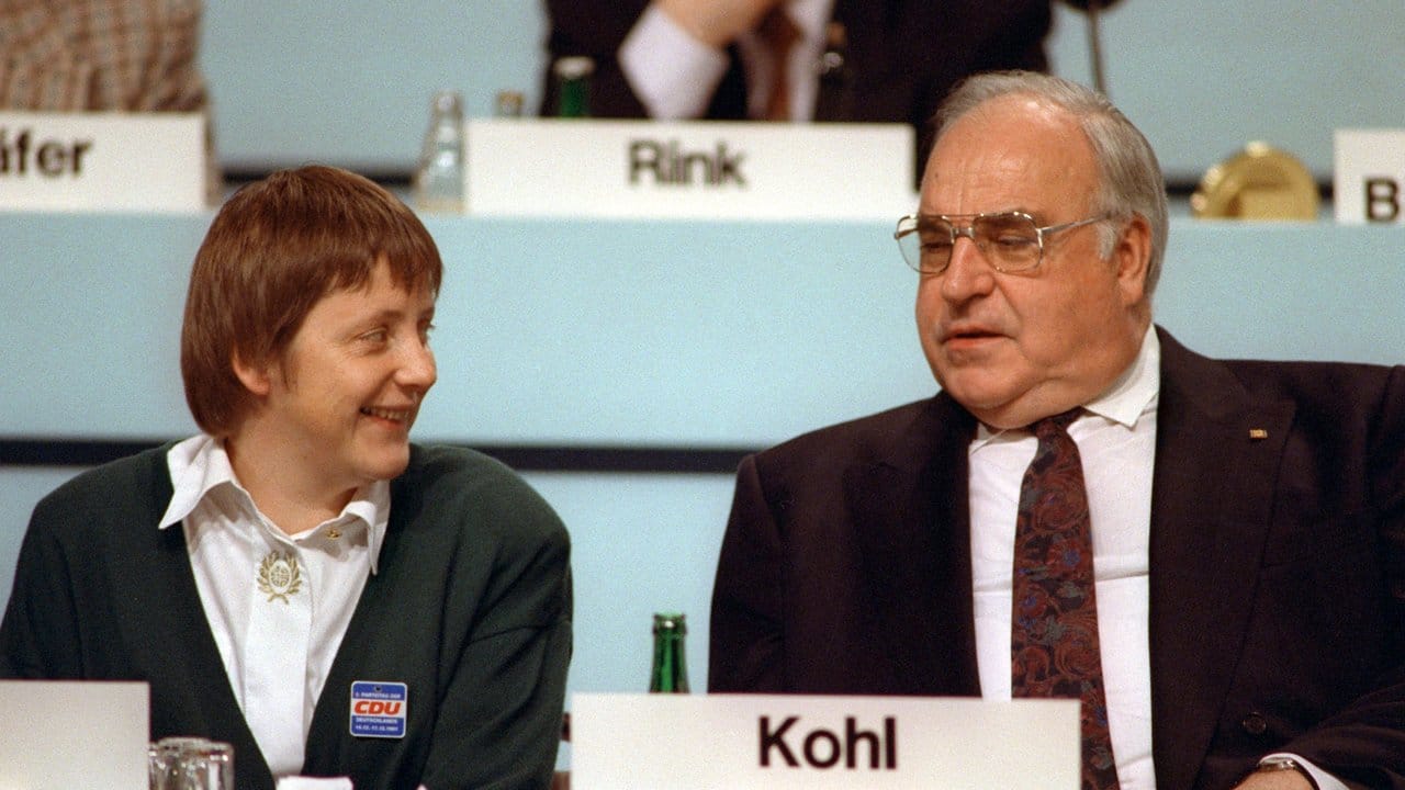 Der damalige Bundeskanzler Helmut Kohl (CDU) und Angela Merkel (CDU), ihrerzeit Frauenministerin, sprechen während des Parteitags der CDU im Kulturpalast 1991.