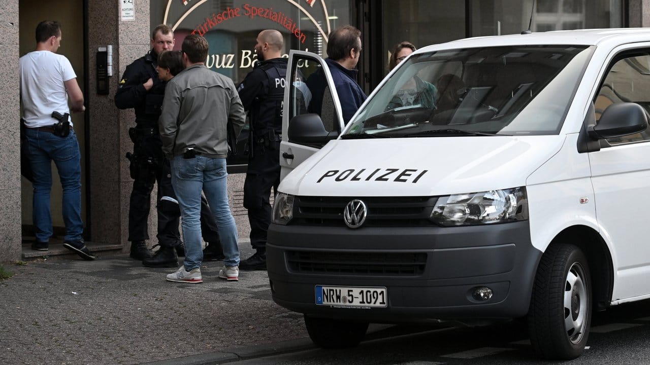 Polizeibeamte stehen vor einem Haus in der Josef-Schregel-Straße in Düren, das wegen Terrorverdachts durchsucht wird.