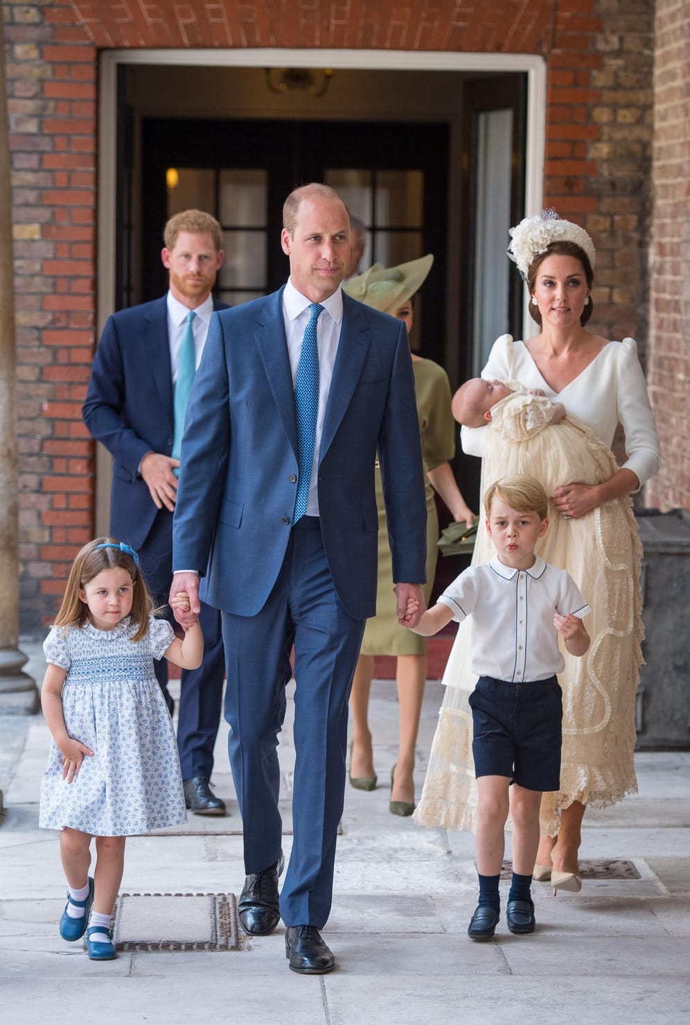 Juli 2018: Bei der Taufe von Louis erscheint die ganze Familie. Charlotte und George halten fest die Hand von Papa William und Kate trägt ihr jüngstes Kind auf dem Arm, das wie die anderen Kinder zuvor das traditionelle Taufkleid trägt.