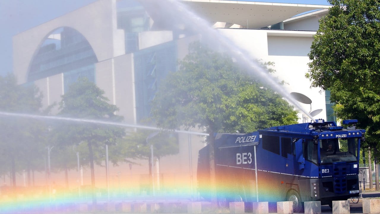 Bei Temperaturen um 30 Grad und extremer Trockenheit bewässert ein Wasserwerfer der Polizei die Grünanlagen vor dem Bundeskanzleramt.