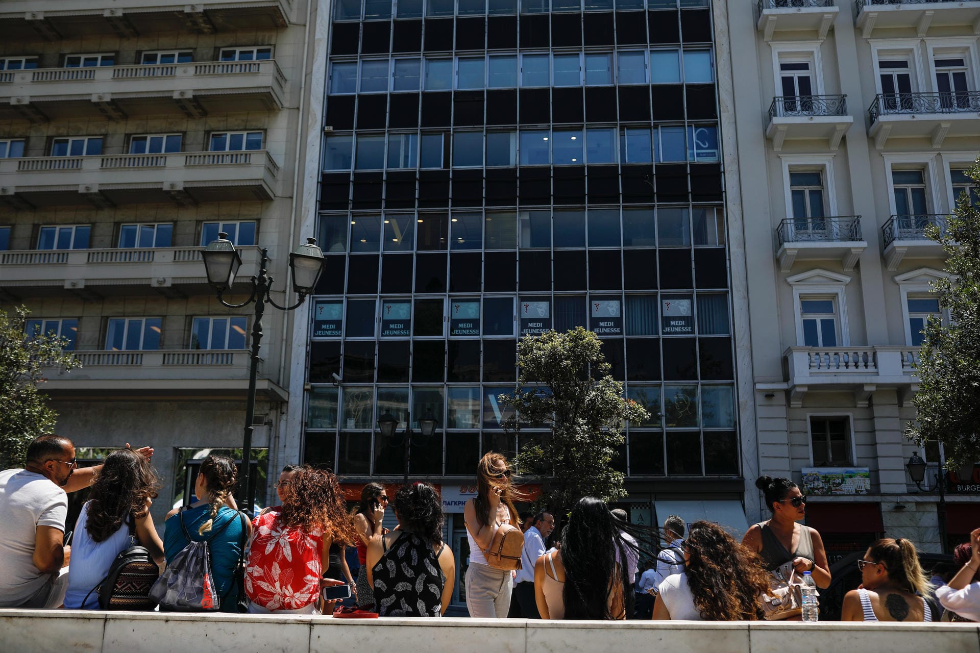 Menschen versammeln sich vor einem Gebäude. Das Beben hatte eine Stärke von 5,0. Das Zentrum lag rund 25 Kilometer nordwestlich der griechischen Hauptstadt.