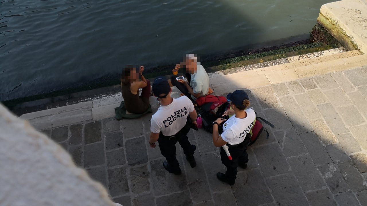 Erwischt: Die beiden deutschen Touristen werden von Polizisten an der Treppe der Rialto-Brücke angesprochen.