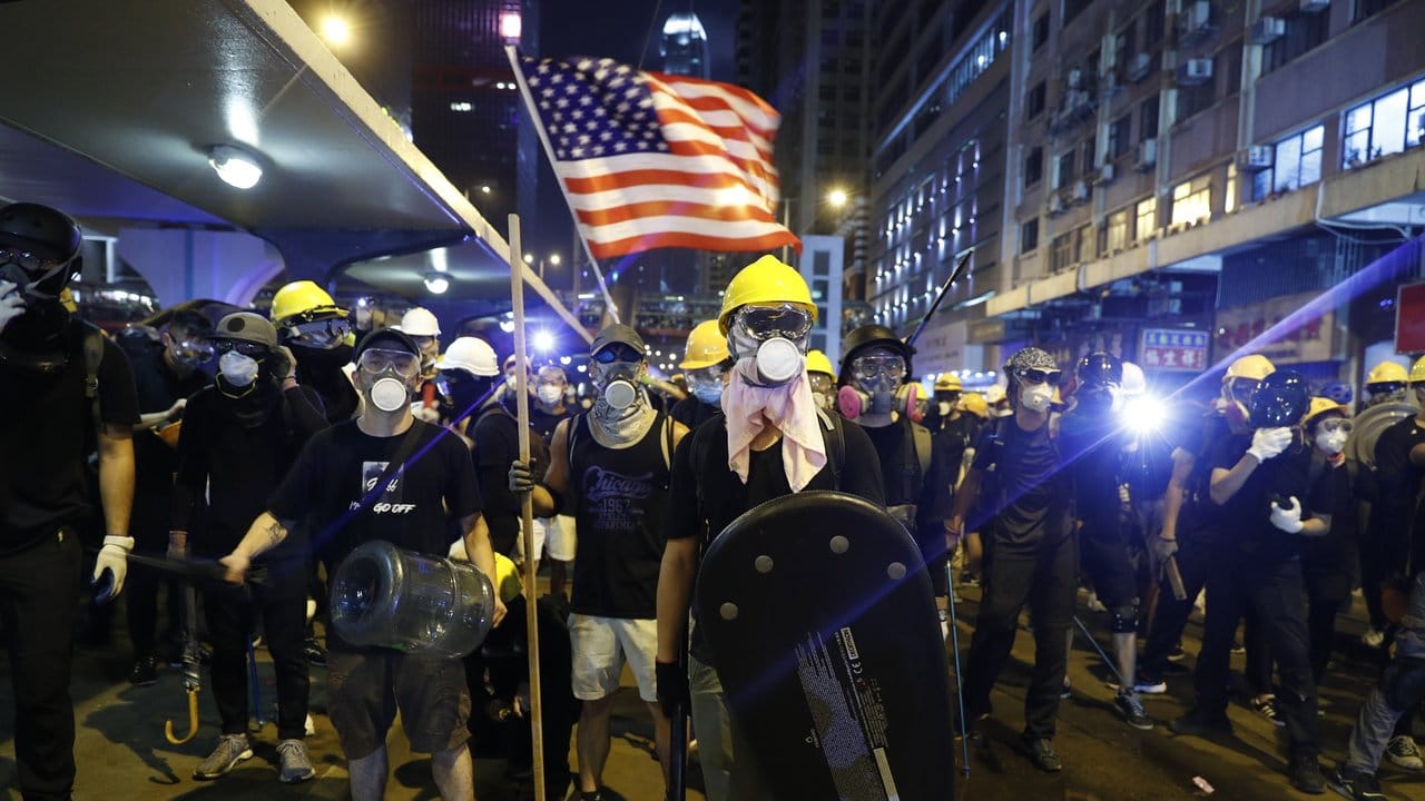 Demonstranten schwenken eine US-Flagge und bereiten sich auf die Konfrontation mit der Polizei vor.