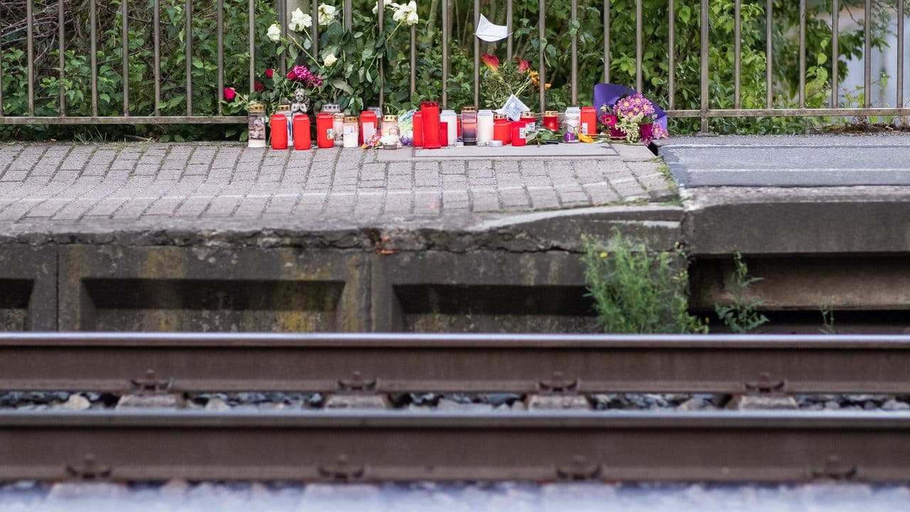 Blumen und Kerzen stehen an Gleis eins am Bahnhof.