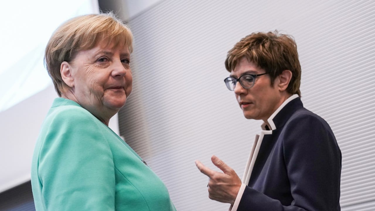 Angela Merkel und Annegret Kramp-Karrenbauer sprechen vor einer Fraktionssitzung.