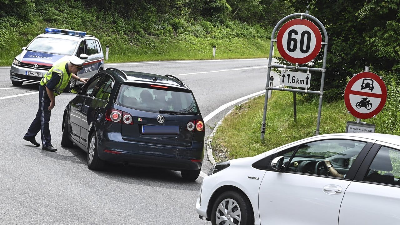 Hier geht's nicht weiter: Ein Polizist hält Autos auf einer Straße bei Innsbruck an.