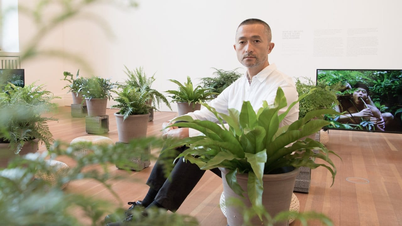 Der Künstler Zheng Bo sitzt in seiner Installation in der Ausstellung "Garten der irdischen Freuden".