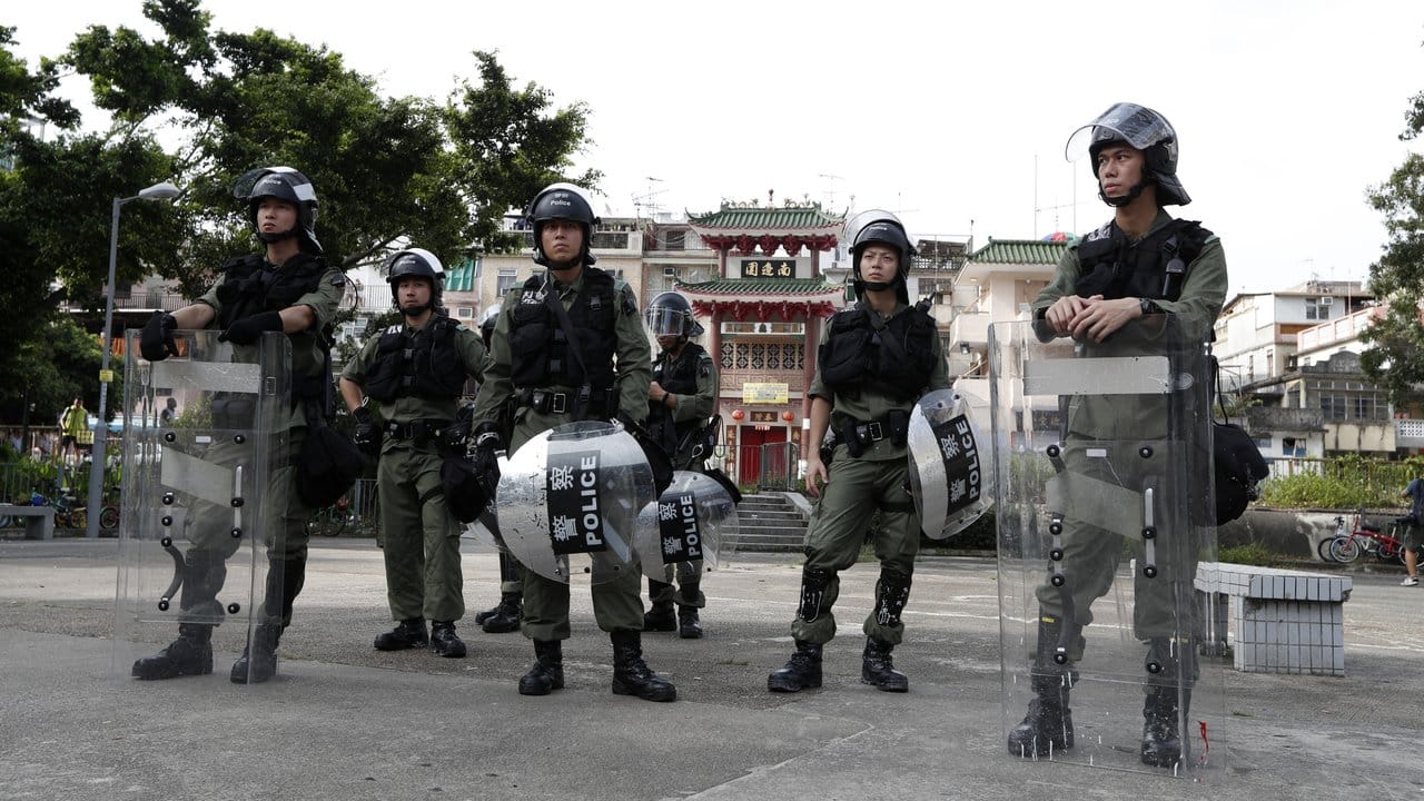 Die Polizei bezieht in schwerer Schutzausrüstung Stellung am Rande der Demonstration.