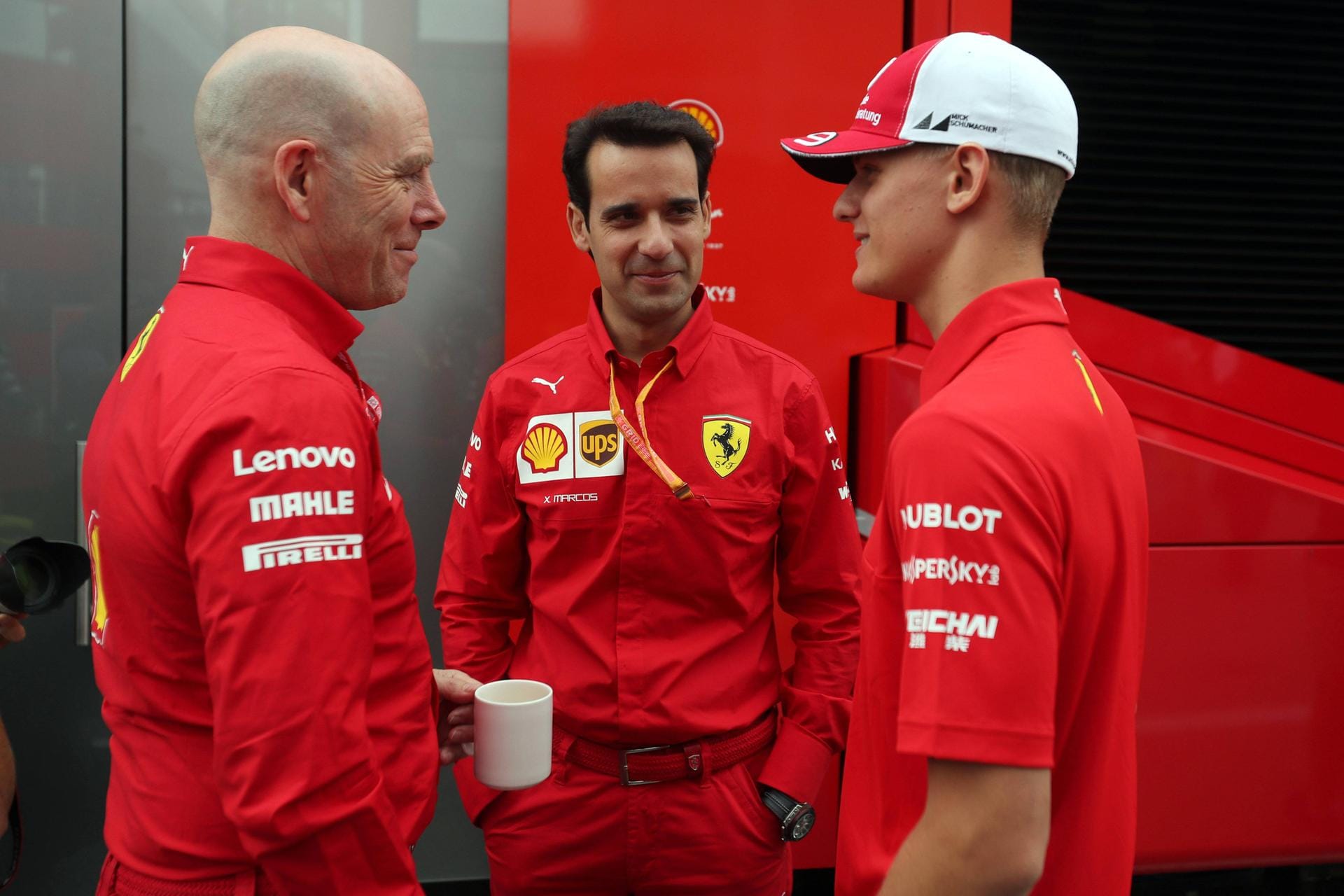 Mick Schumacher (r.) an der Rennstrecke mit Mitarbeitern von Ferrari.