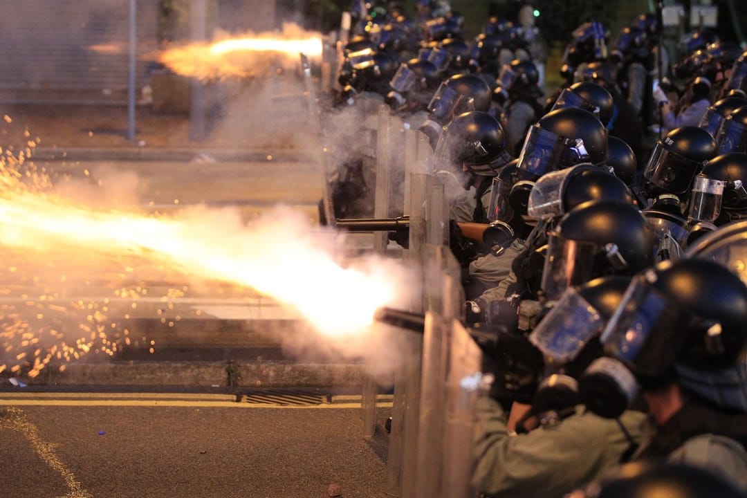 Die Polizei von Hongkong feuert Tränengas auf Demonstranten.