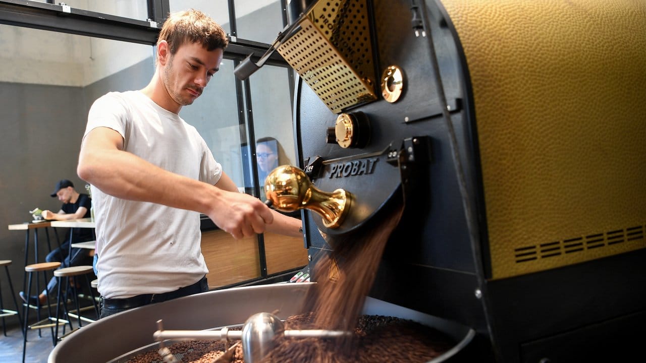 Philipp Reichel füllt im Kaffee 9 die gerösteten Kaffeebohnen aus dem Kaffeeröster ab.
