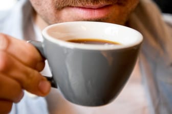 Ein junger Mann trinkt im Kaffee 9 einen Kaffee.