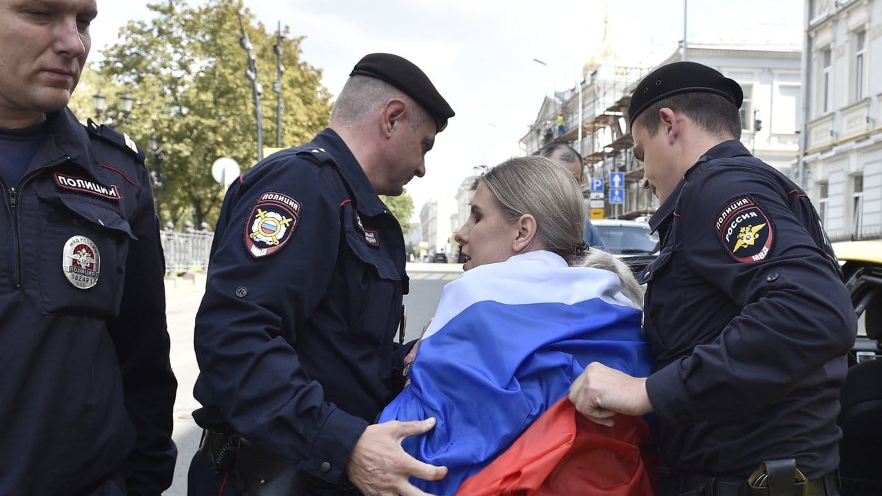 Russische Polizeibeamte verhaften eine Oppositionelle bei der nicht genehmigten Kundgebung im Zentrum der Stadt.