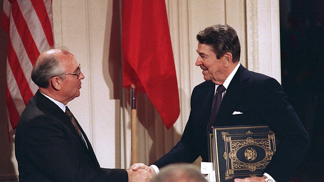 Der sowjetische Staatschef Michail Gorbatschow (l) und US-Präsident Ronald Reagan geben sich die Hand, nachdem beide den Intermediate Range Nuclear Forces Treaty (INF-Vertrag) 1987 im Weißen Haus unterzeichnet haben.