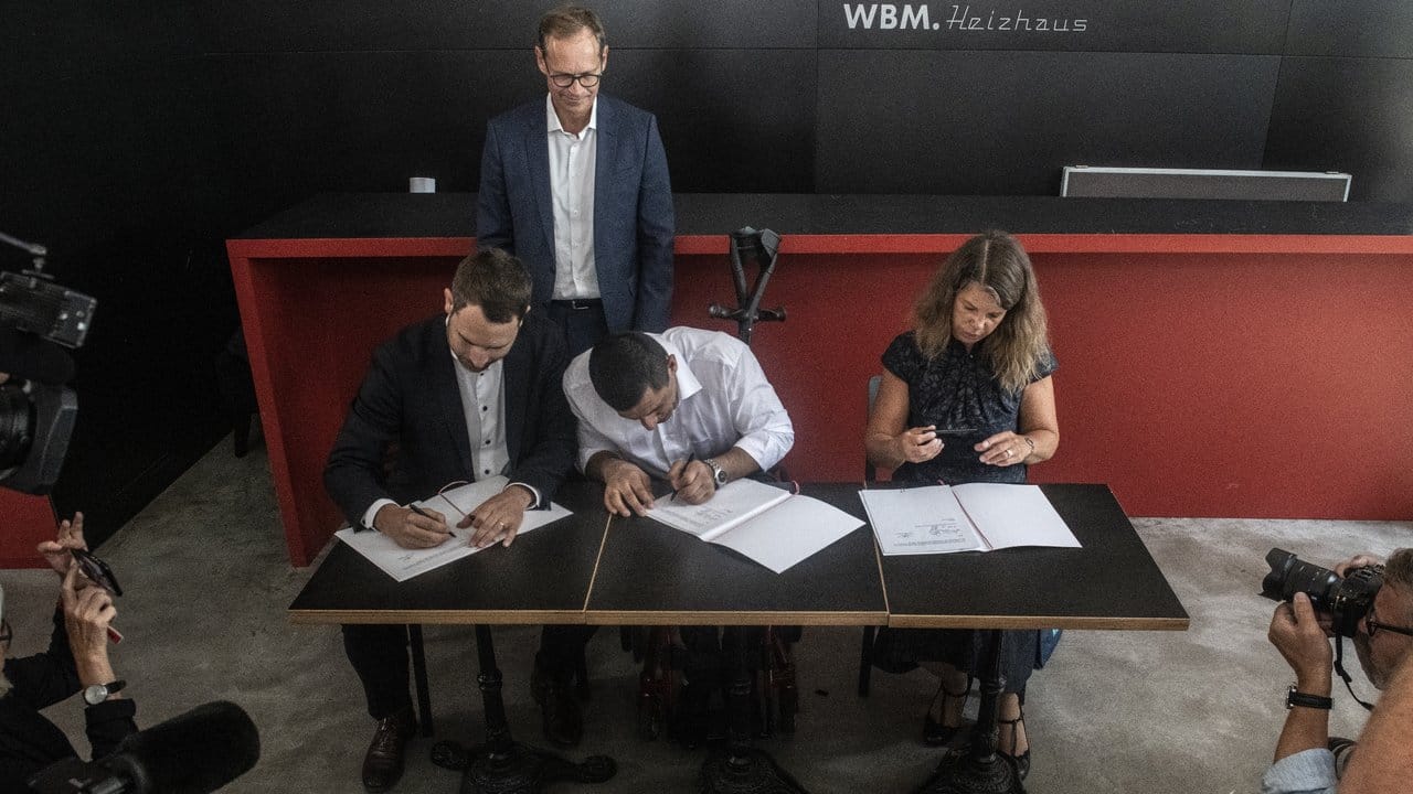 Im Beisein von Bürgermeister Michael Müller (hinten) unterzeichnet Rahim Nagibulla (M) den ersten Arbeitsvertrag im Rahmen des bundesweit einmaligen Projekts "Solidarisches Grundeinkommen". Im Beisein von Bürgermeister Michael Müller (hinten) unterzeichnet Rahim Nagibulla (M) den ersten Arbeitsvertrag im Rahmen des bundesweit einmaligen Projekts "Solidarisches Grundeinkommen".