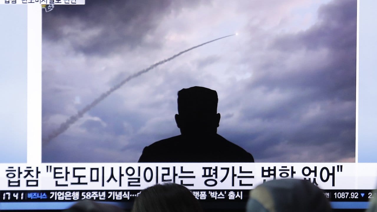 Passanten verfolgen an einem Bahnhof eine Nachrichtensendung über einen Raketentest in Nordkorea.