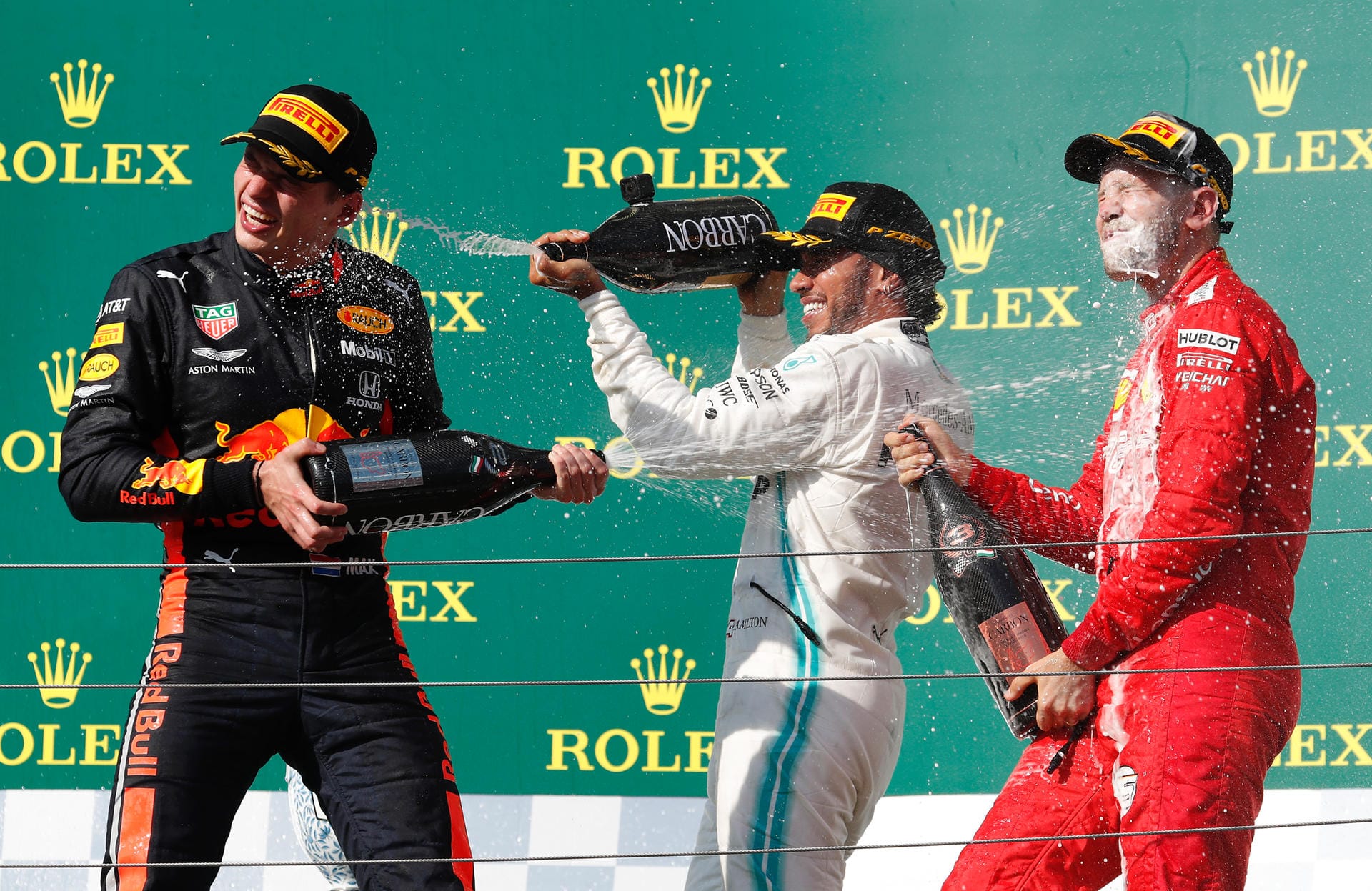 Lewis Hamilton (M.) hat den großen Preis von Ungarn gewonnen. Der 34-Jährige setzte sich vor Max Verstappen (li.) und Sebastian Vettel durch. Es war bereits der achte Saisonsieg des Mercedes-Piloten.
