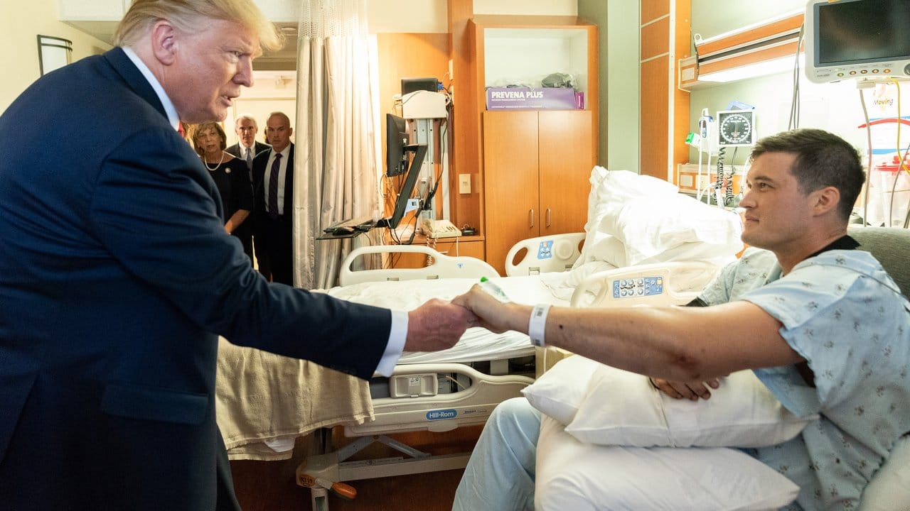 Trump reicht einem Überlebenden des Massakers von Dayton die Hand.