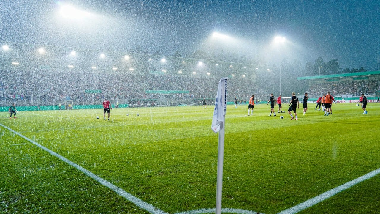 Während der DFB-Pokal-PArtie zwischen dem SV Sandhausen und Borussia Mönchengladbach zieht ein heftiges Gewitter über das Sandhausener Sandhausener Hardtwaldstadion hinweg.