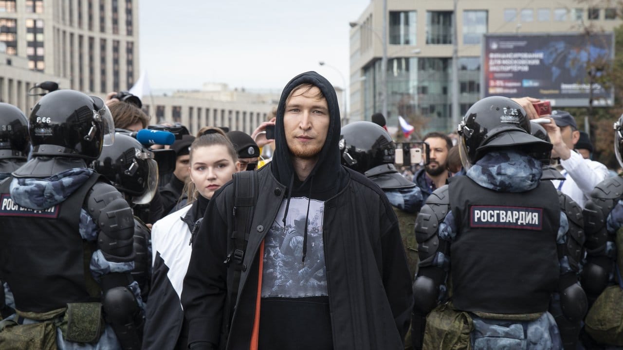 Mitglieder der russischen Elektro-Band IC3PEAK verlassen nach einem Auftritt die Proteste, während Menschen für faire und freie Wahlen demonstrieren.