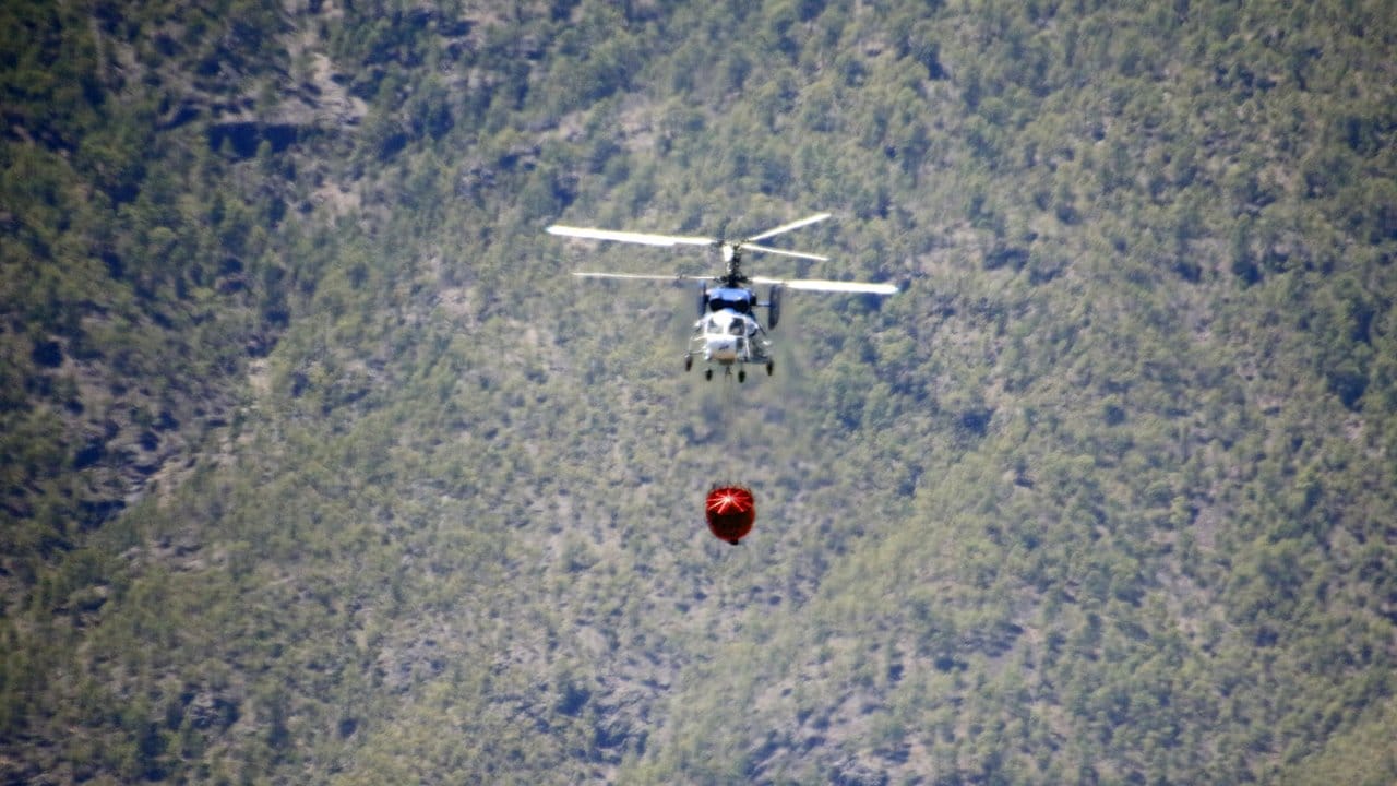 Ein Hubschrauber fliegt zu einem Waldbrand in der Nähe von Artenara.