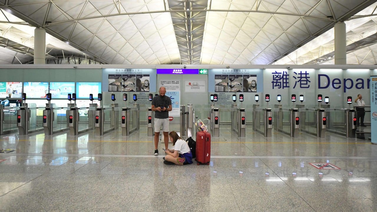 Reisende warten nach der ersten Sperrung am Montag im Terminal des Flughafens.