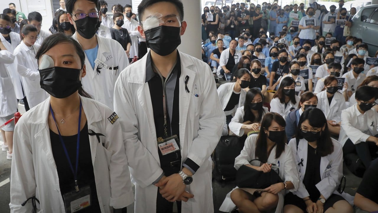 In einem Hongkonger Krankenhaus protestiert das Personal mit Augenklappe und Mundschutz gegen die Brutalität der Polizei gegenüber den Demonstranten.
