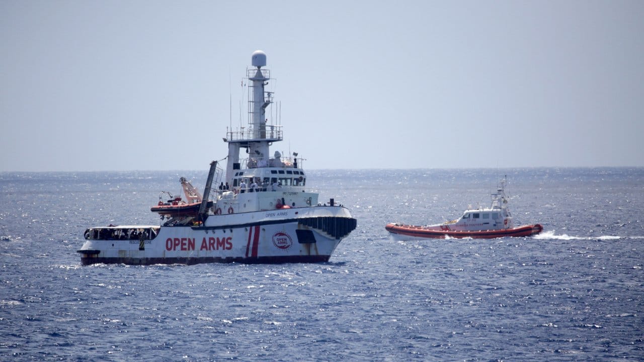 Ein Boot der italienischen Küstenwache (r) kreuzt neben dem Rettungsschiff "Open Arms" vor Lampedusa.