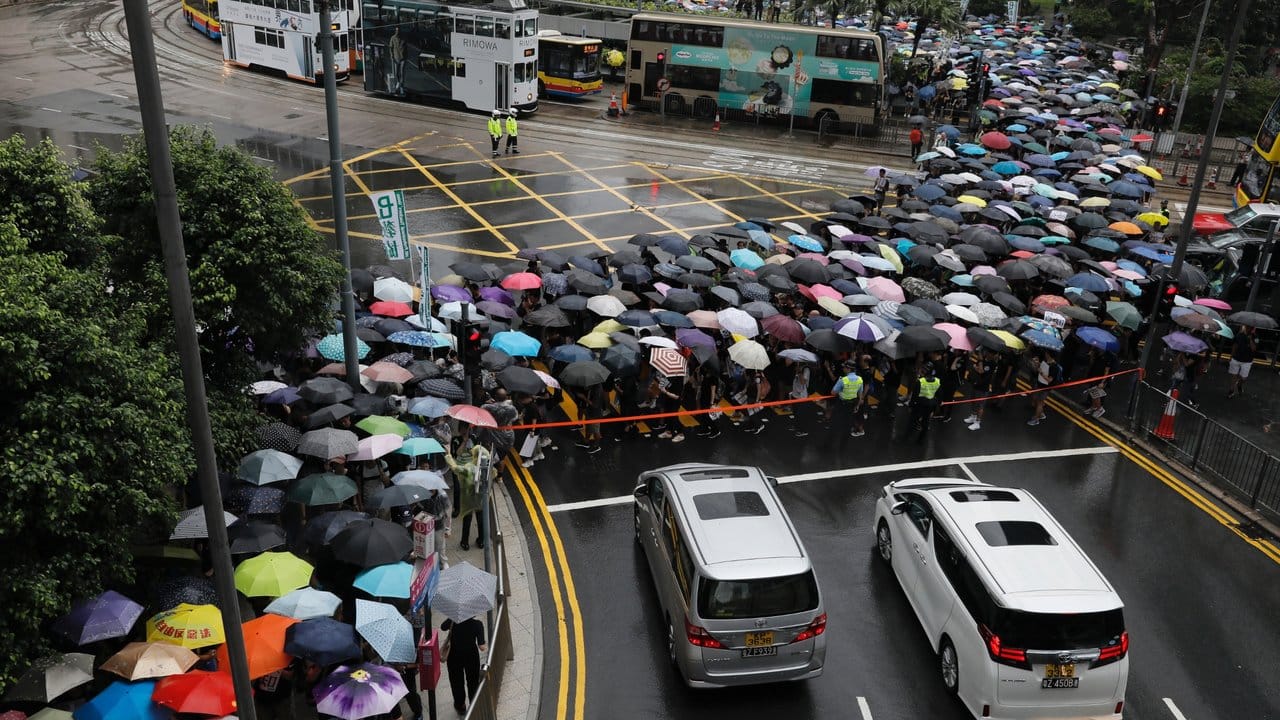 Mit Regenschirmen haben sich Hongkonger versammelt, um an einer von Lehrern organisiserten Demonstration teilzunehmen.