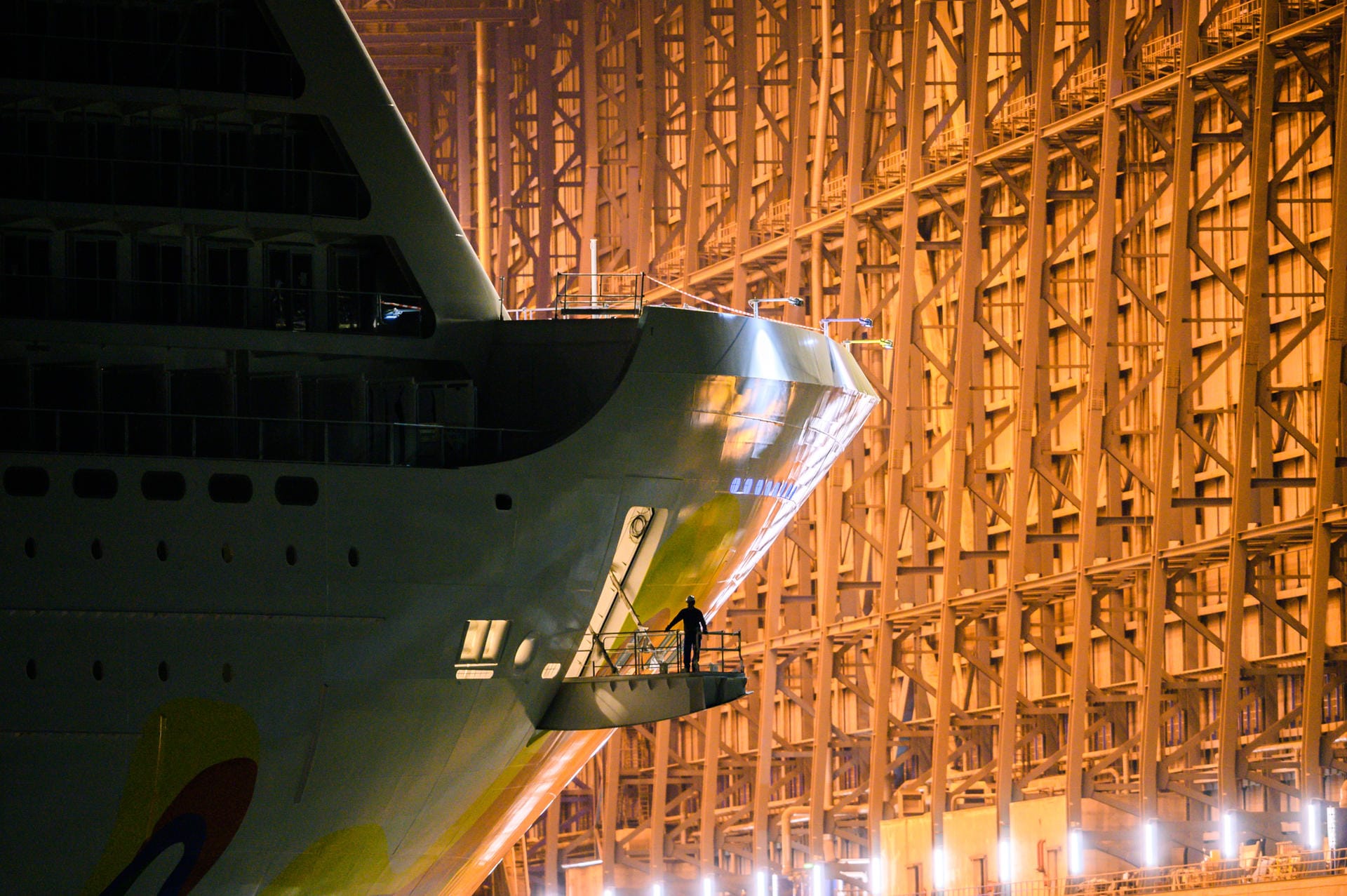 Ein Arbeiter steht an einer Öffnung am Bug des Kreuzfahrtschiffs "Norwegian Encore", während es das Baudock der Meyer Werft verlässt: Das Schiff ist 330 Meter lang.