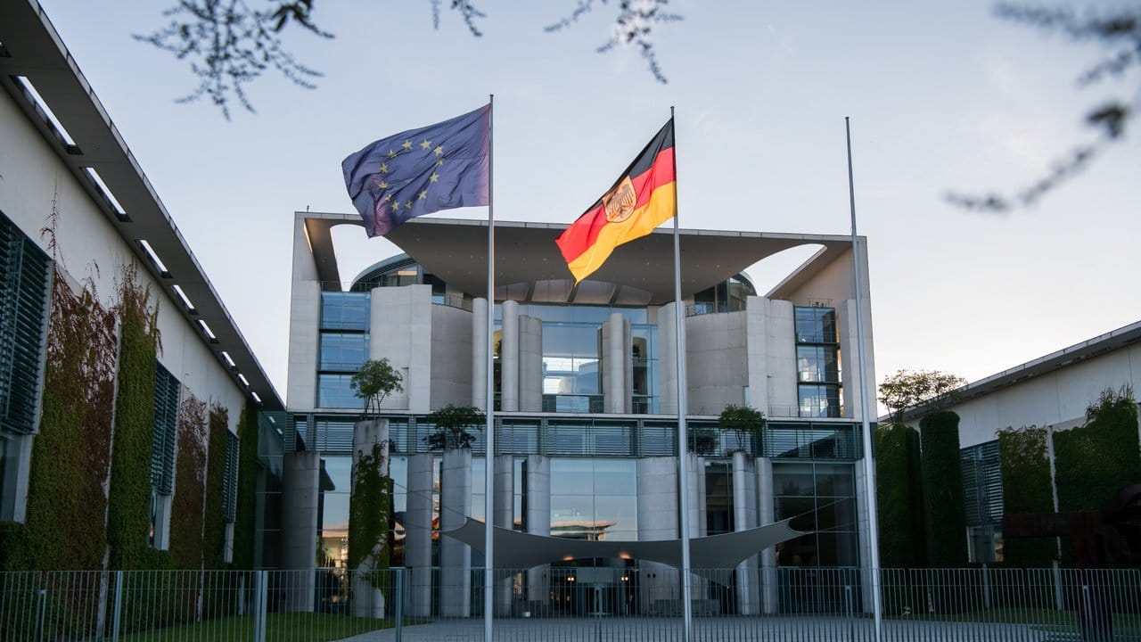 Die deutsche und die EU-Flagge vor dem Kanzleramt in Berlin.