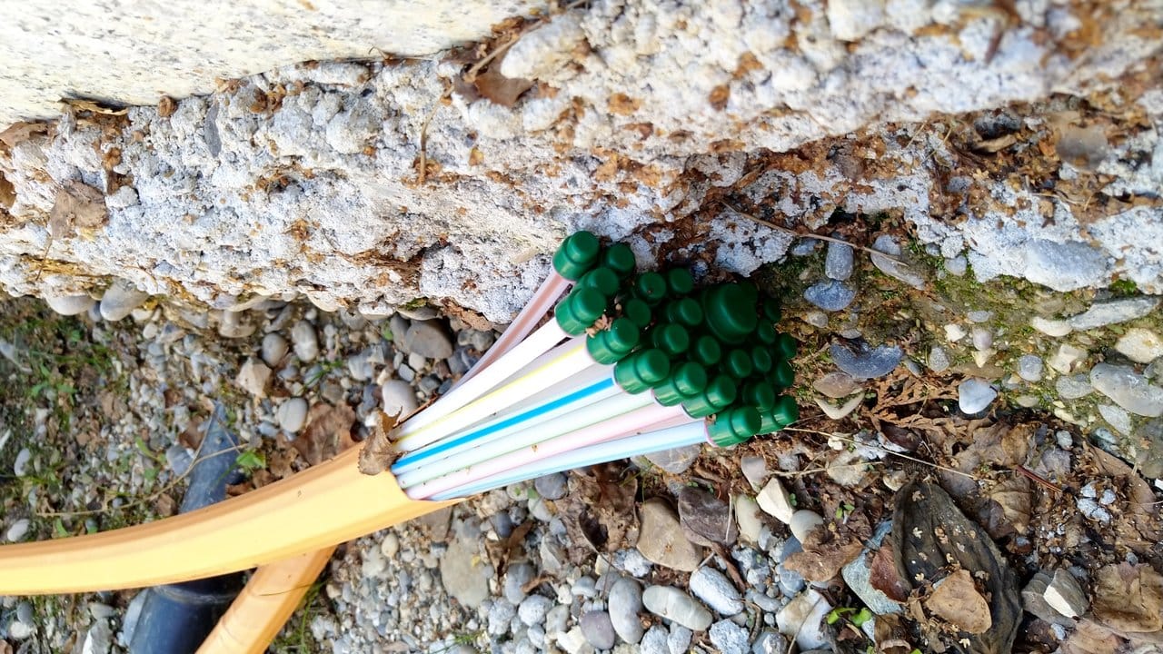 Wer bislang noch nicht an die Glasfaser-Leitungen angebunden ist, bekommt solche Rohre mit der sogenannten Erdrakete oder mit einem Spülbohrer durch den Gartenboden bis zur Hauswand verlegt.