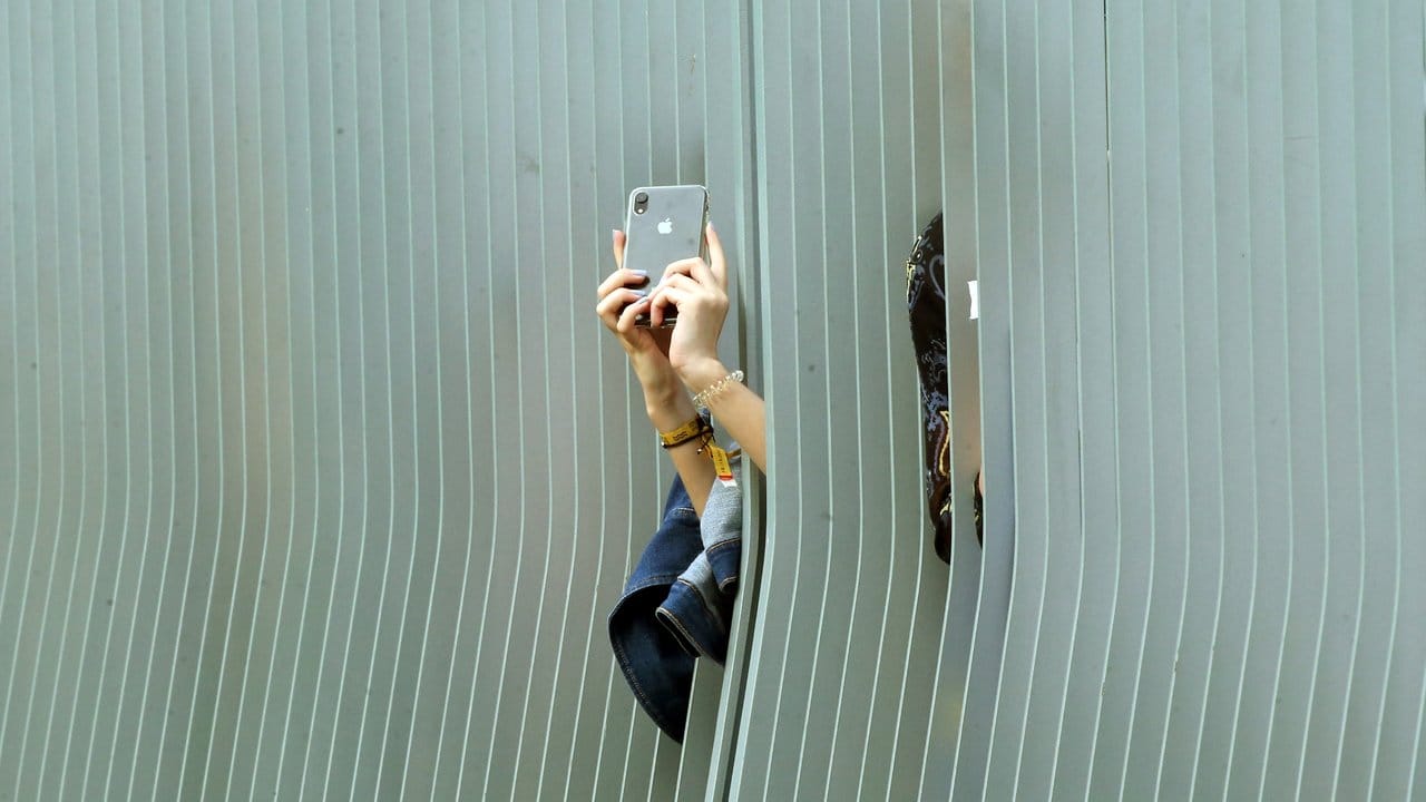 Zaungäste versuchen durch ein Gitter zum Ehrenhof des Bundeskanzleramtes Fotos zu machen.