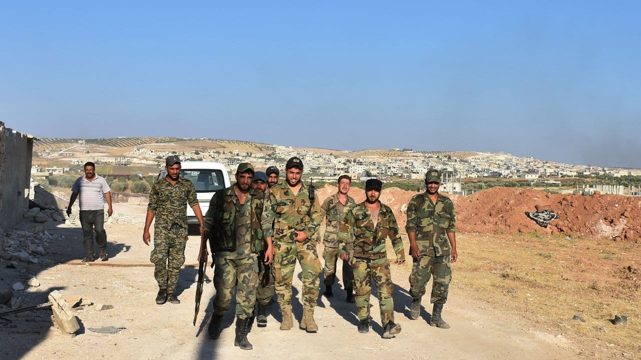 Syrische Soldaten gehen durch die Stadt Chan Schaichun.