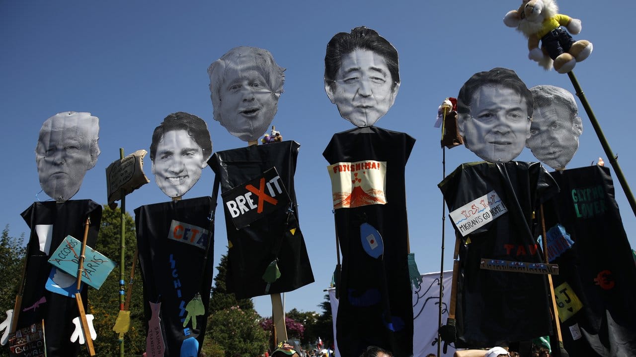 Demonstranten tragen während eines Protestmarschs gegen den G7-Gipfel Figuren, die die teilnehmenden Staats- und Regierungschefs darstellen sollen.
