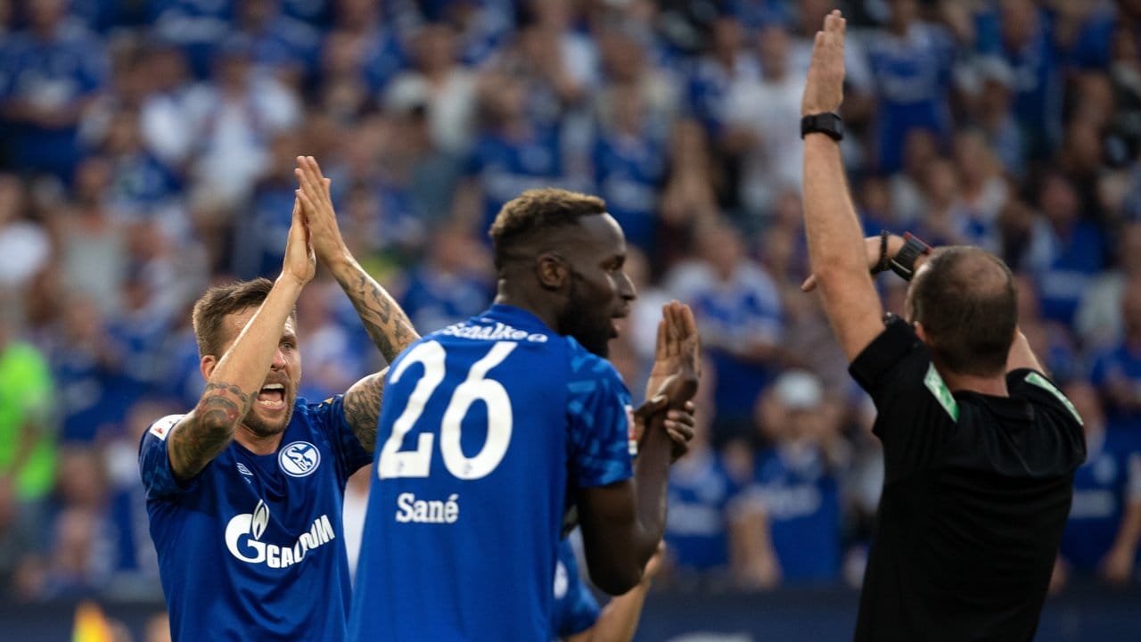 Schalkes Sane (M) und Burgstaller (l) beschweren sich bei Schiedsrichter Fritz über ein nicht gegebenes Handspiel.