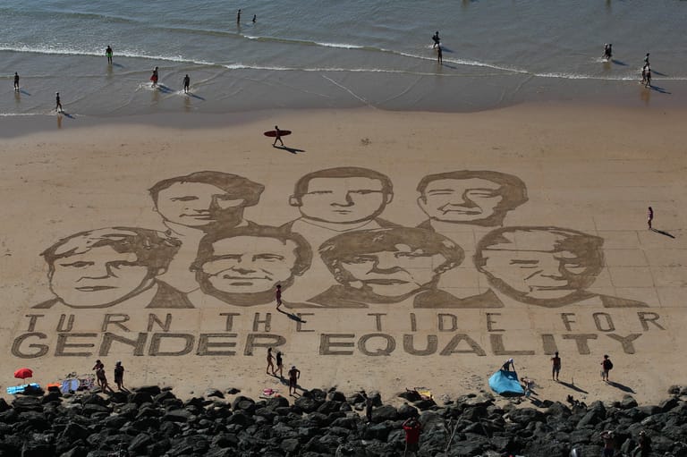 Protest im Sand: Aktivisten haben am Strand von Biarritz die Porträts der Teilnehmenden und die Nachricht "Turn the tide for Gender Equality" (dt. "Wendet das Blatt hin zu Geschlechtergleichheit.") in den Sand gemalt.