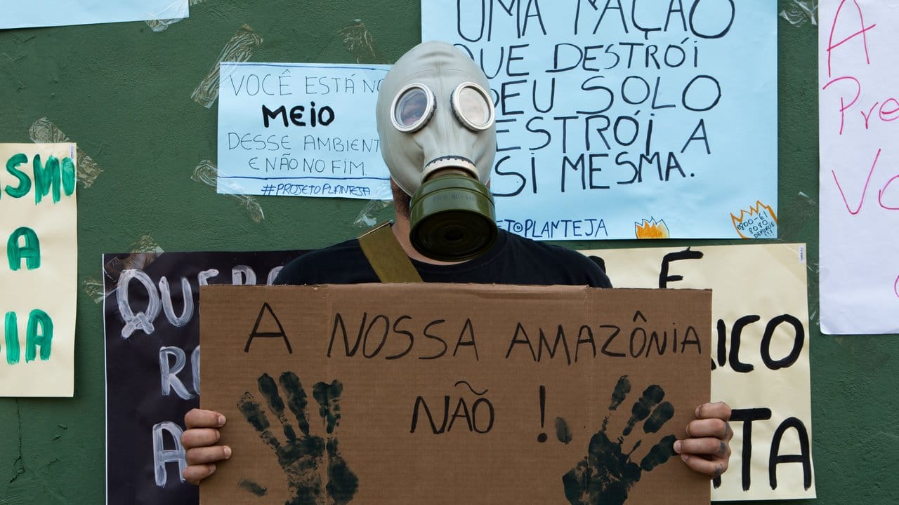 Ein Mann protestiert mit einer Gasmaske und einem Schild mit der Aufschrift "Unser Amazonas nicht!" in der Stadt Porto Velho.