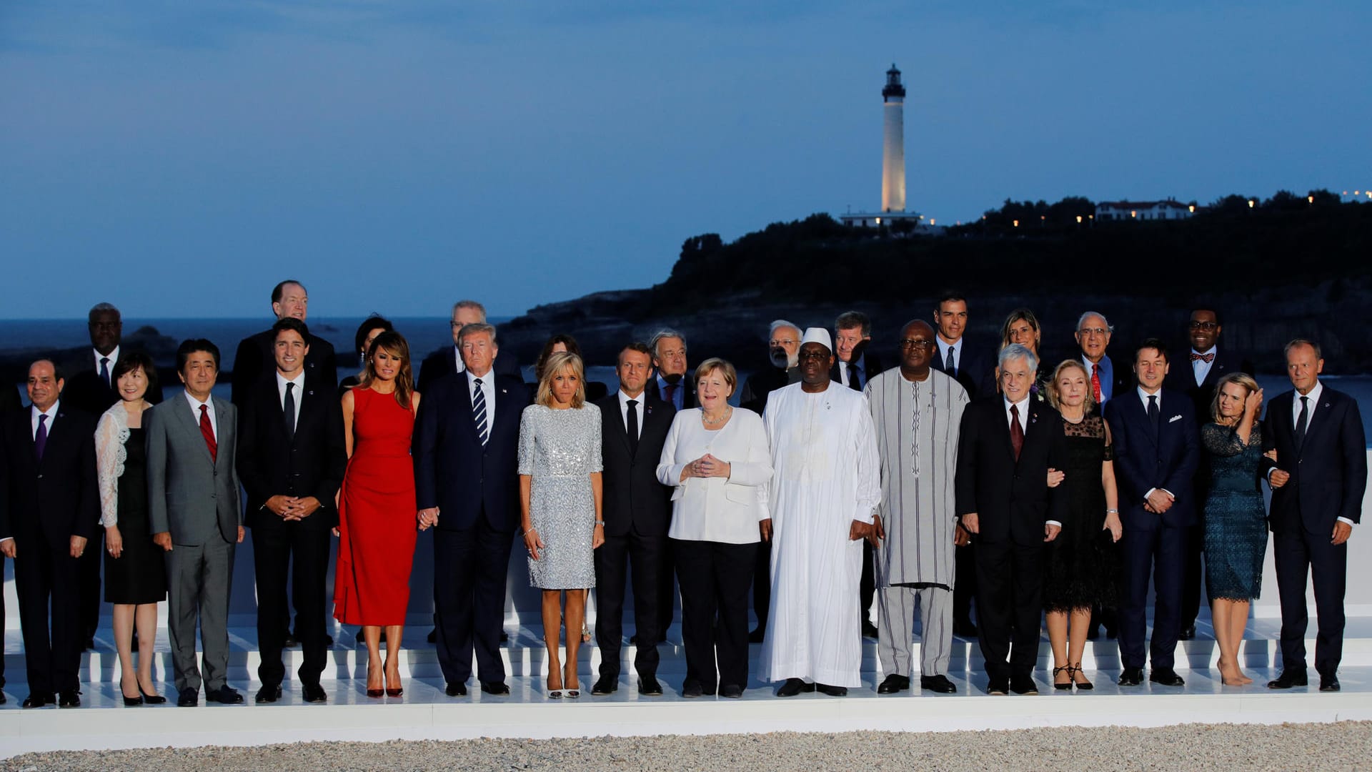 Familienfoto: Die Staats- und Regierungschefs mit Ehepartnern – von links: Japans Premierminister Shinzō Abe, Kanadas Premier Justin Trudeau, US-Präsident Trump, Gastgeber Emmanuel Macron, Angela Merkel und der geschäftsführende italienische Premier Giuseppe Conte mit geladenen Gästen.