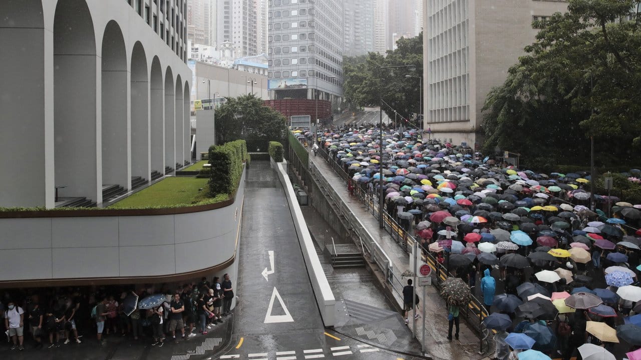 Teilnehmer einer prodemokratischen Demonstration ziehen mit Regenschirmen durch die Straßen von Hongkong.