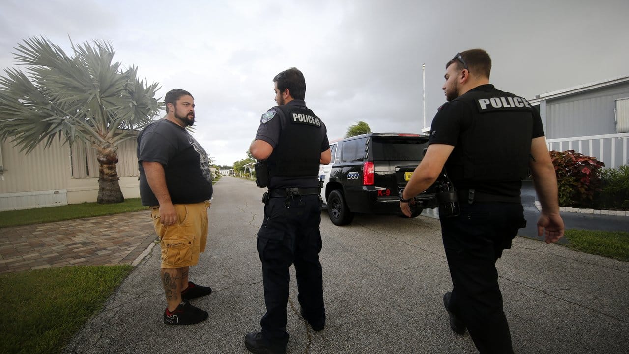 Polizeibeamte sprechen mit einem Anwohner in Florida über die bevorstehende Evakuierung. Polizeibeamte sprechen mit einem Anwohner in Florida über die bevorstehende Evakuierung.