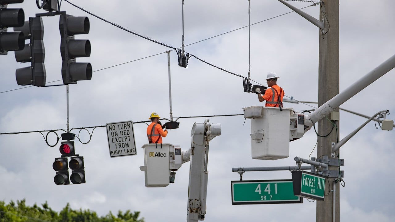 Mitarbeiter des Palm Beach County im Süden des US-Bundesstaats Florida installieren Ampeln, die vor der Ankunft des Hurrikans vorsorglich demontiert worden waren.